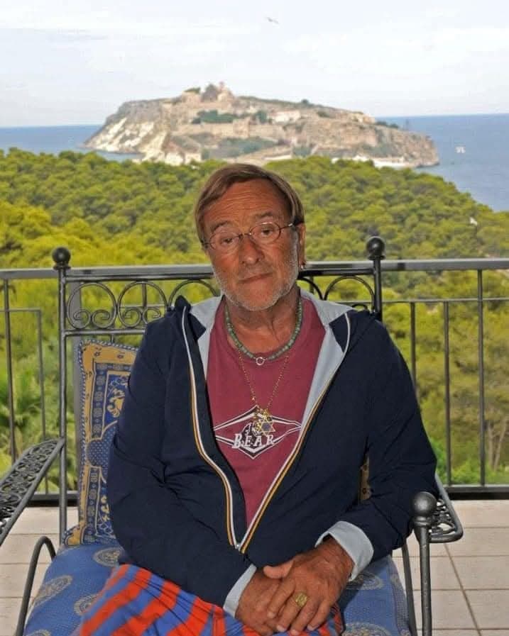 Lucio Dalla seduto alle Isole Tremiti con l'isola di San Nicola sullo sfondo